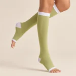 Mi-bas de contention vert pomme pieds ouverts, compression 15-20mmHg, avec bande et talon blancs.